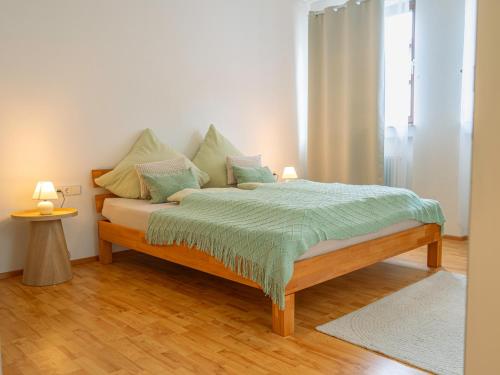 a bedroom with a bed with a green comforter at Einzigartiges Scandi-Apartment in der Innenstadt ruhig, stilvoll & mit WLAN in Riedlingen
