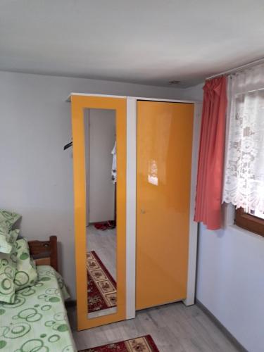 a room with a door and a room with a bed at Casa boierului Imbri in Cîrţişoara