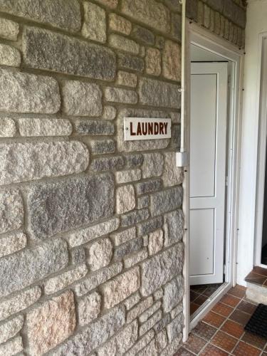 a brick wall with a sign that reads laundry at Scalpay@Knock View Apartments, Sleat, Isle of Skye in Teangue