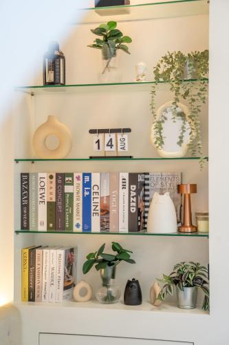 a book shelf filled with books and plants at The Pinnacle Katanoi in Kata Beach