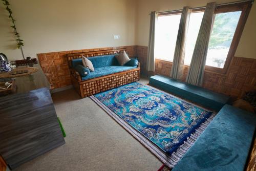 a living room with a blue couch and a rug at Echoes of Nirvana in Theog