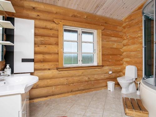 a bathroom with wooden walls and a toilet and a window at 10 person holiday home in Frøstrup-By Traum in Frøstrup