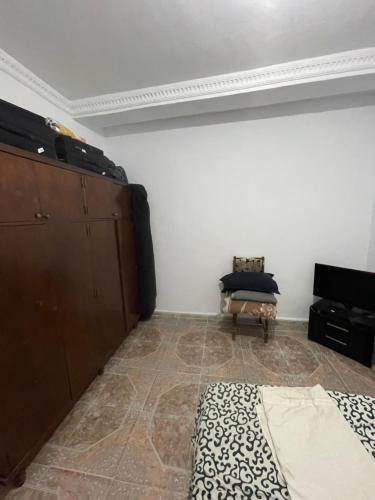 ein Schlafzimmer mit einem Bett, einer Kommode und einem Stuhl in der Unterkunft La Rue Verte Rive in Alger