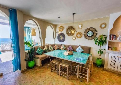 a living room with a table and a couch at Dar Mogador Océan near Taghazout - Surf, colorful village in Taghazout
