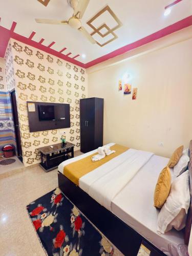 a bedroom with a bed and a flat screen tv at Hotel Chandra Dreams in Varanasi