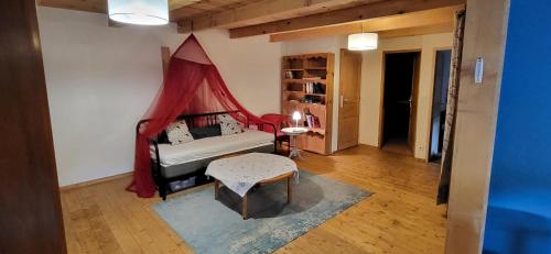 a living room with a bed and a table at Les Estables Belle maison typique du Mezenc in Les Estables