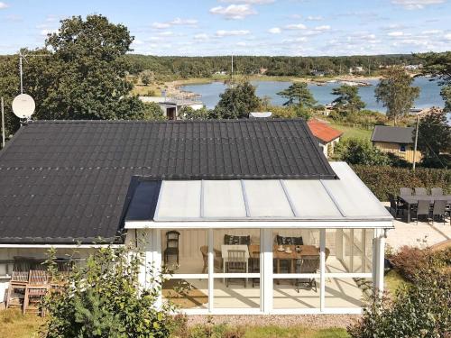 a house with a black roof with a view of a lake at 6 person holiday home in Åskloster-By Traum in Åskloster