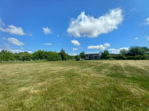 a large grass field with a building in the background at The Dutch Barn in Maidstone