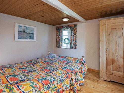 a bedroom with a bed with a colorful comforter and a window at Charming Country Retreat - By Traum Ferienwohnungen in Toftum