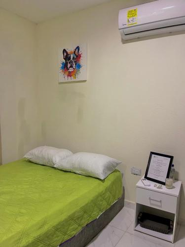 a room with a bed and a laptop on a table at Casa Agarj in Santa Marta