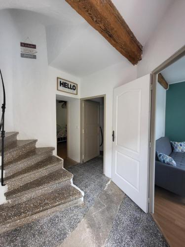 a hallway with stairs and a sign that reads hello at Maison de village Olonzac in Olonzac