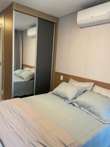 een slaapkamer met een bed en een grote spiegel bij Studio no condomínio Almagah SPaulo in Sao Paulo