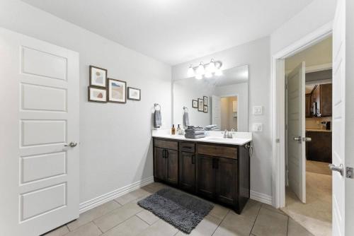 a bathroom with a sink and a mirror at Luxury Home Mins to JPS & Medical City Fort Worth in Fort Worth