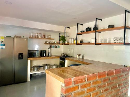 a kitchen with a refrigerator and a brick wall at Casa Agarj in Santa Marta