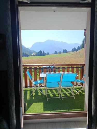 a table and chairs on a balcony with a view of a field at Studio avec vue sur les montagnes à 2 minutes d'un lac in La Morte