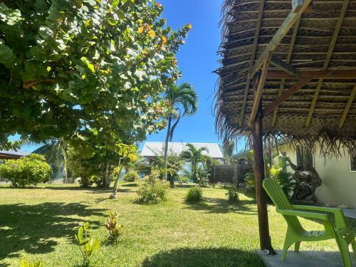 a yard with a green chair and a tree at Le spot in Fare