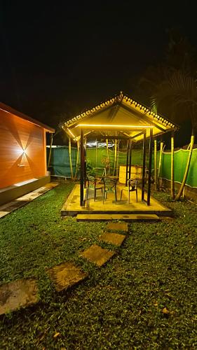 a gazebo with two chairs and a table at night at The Laughing Woods AC Resort in Kotagiri