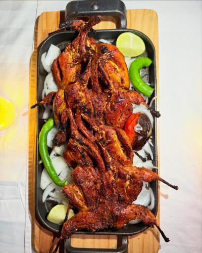 a tray of food with chicken and vegetables on a table at Kabul Qargha Palace Hotel, Restaurant and wedding Hall in Kabul