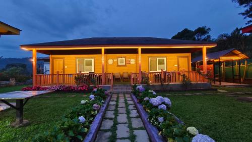 a yellow house with a table and flowers in front of it at The Laughing Woods AC Resort in Kotagiri
