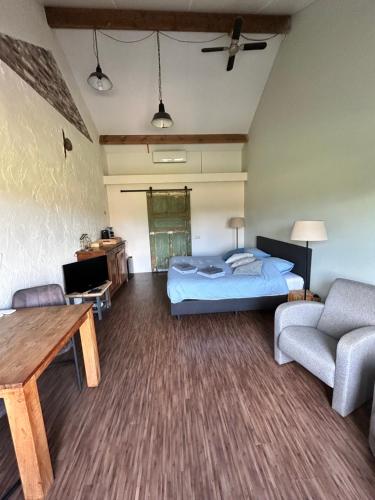 a bedroom with a bed and a couch and a table at Hoeve Delshorst in Heibloem