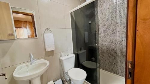 a bathroom with a toilet and a sink and a shower at Loft pertinho do Aeroporto de Navegantes! in Navegantes