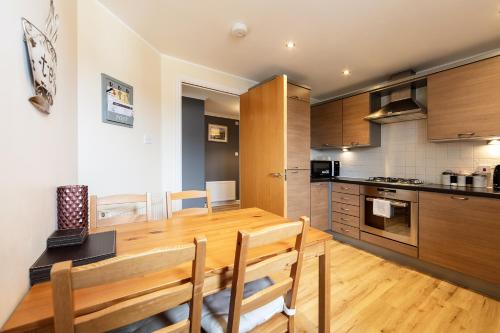 a kitchen and dining room with a wooden table at Jacobs Apartment Edinburgh in Edinburgh