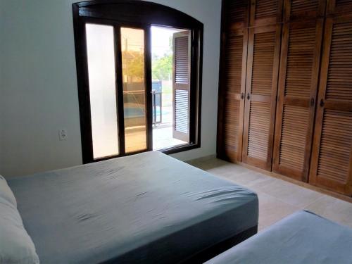 una camera da letto con un letto grande e una finestra di Casa geminada com piscina exclusiva ad Arroio do Sal