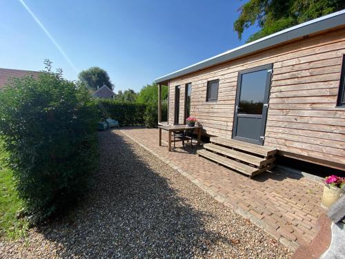 a small house with a picnic table next to it at Hoeve Delshorst in Heibloem