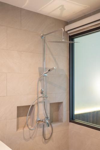 a shower in a bathroom next to a window at The Pinnacle Katanoi in Kata Beach