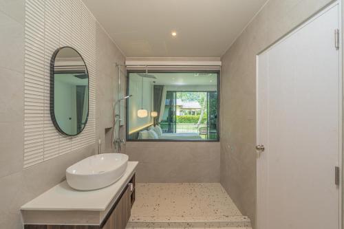 a bathroom with a sink and a mirror at The Pinnacle Katanoi in Kata Beach