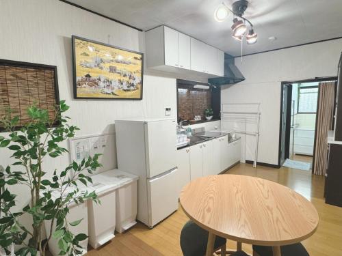 a kitchen with a wooden table and a table and a dining room at Sakura House in Yatomi 
