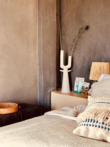 a bedroom with a bed and a vase on a table at Le Hameau des Cascades in Aghnajane