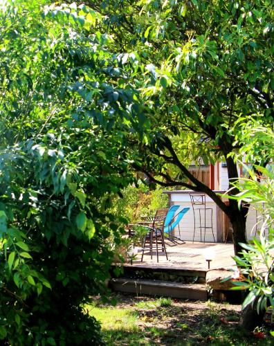 two chairs sitting on a patio under a tree at Hôtel Mas Vidau Porte des Alpilles in Saint-Étienne-du-Grès