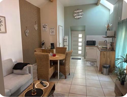 a living room with a table and a kitchen at Parenthèse romantique avec spa privatif in Deyvillers