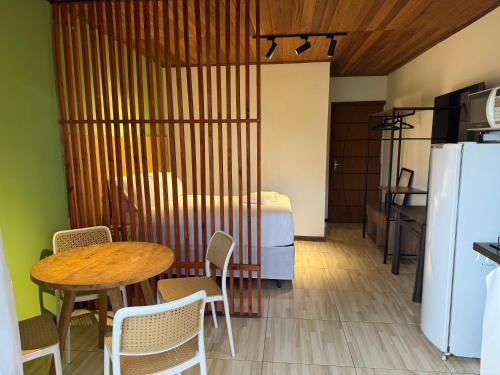 Habitación con mesa, cama y cocina. en Pituba Vile - Apartamento Jardim, en Itacaré