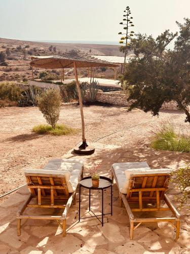 two chairs and a table with an umbrella at Le Hameau des Cascades in Aghnajane