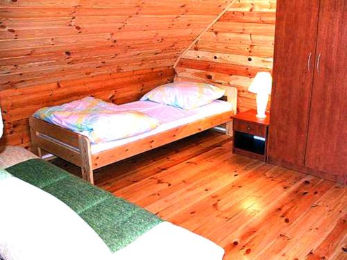 a bedroom with a bed in a wooden room at Neptun Ψ Domki - Jastrzębia Góra Centrum in Władysławowo