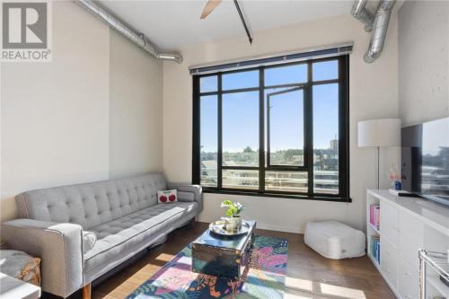 a living room with a couch and a large window at Downtown one bedroom apartment 2 in Victoria
