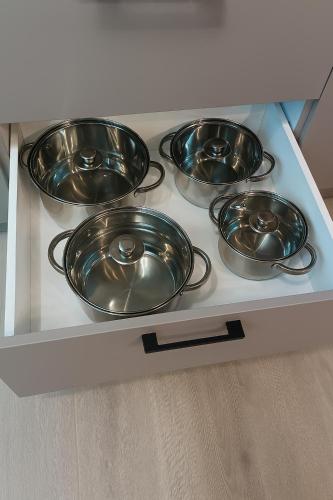 four metal pans sitting on a stove in a kitchen at Apartamenty na Widoku Chłopy in Chłopy