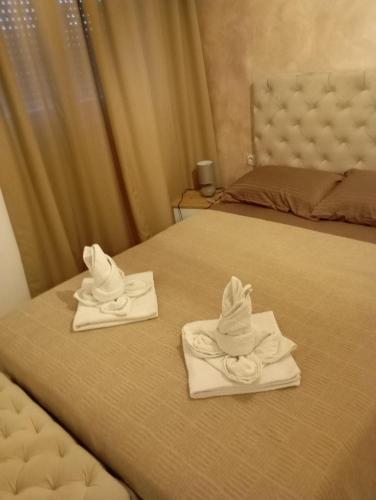 two towels are sitting on top of a bed at Apartment Aleksandrija in Niš
