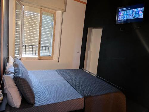 a bedroom with a bed with a tv on the wall at UNIQUE Apartments in Faenza
