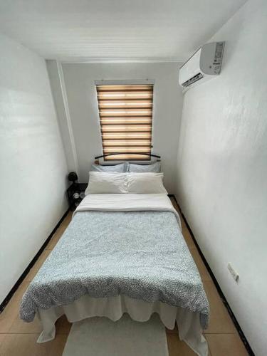 a small bedroom with a bed in a room at Relaxing 3bedroom home with outdoor dining NUVALI in Calamba