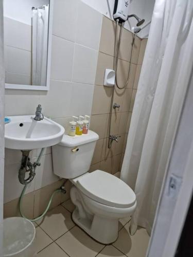 a bathroom with a toilet and a sink and a shower at Relaxing 3bedroom home with outdoor dining NUVALI in Calamba