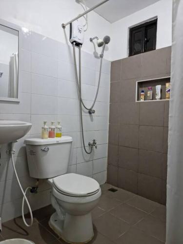 a bathroom with a toilet and a shower at Relaxing 3bedroom home with outdoor dining NUVALI in Calamba