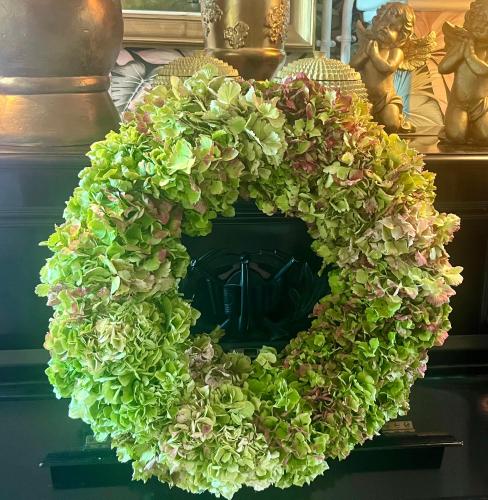 a green ivy wreath on a table with other items at Huyze-peppins in Maldegem