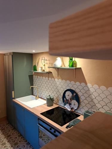 a kitchen with a sink and a stove top oven at Écolieu La Bernarde - Gîte Nature in Dompnac