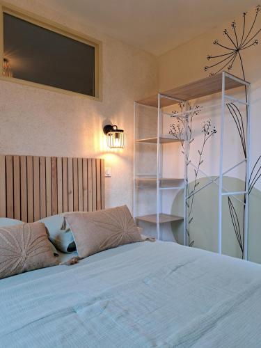 a bedroom with a bed with a tv on the wall at Écolieu La Bernarde - Gîte Nature in Dompnac