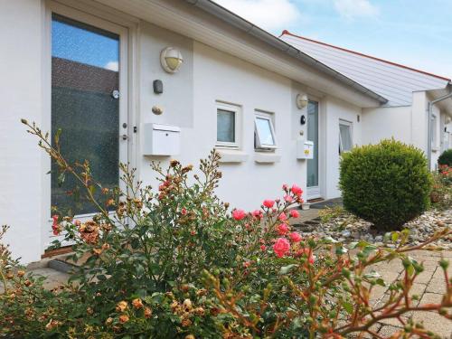a white house with a green door and flowers at 4 person holiday home in Ærøskøbing-By Traum in Ærøskøbing