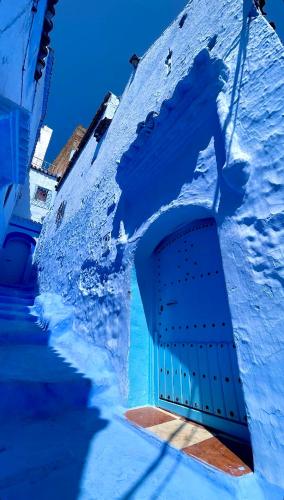 a blue building with a door in the side of it at DAR AMRANi in Chefchaouene