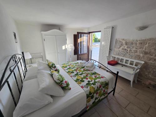 a bedroom with two beds and a table and a window at Trullo Olivia con piscina riscaldata, natura e relax in Martina Franca